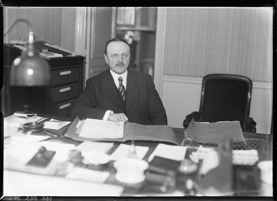 Gabriel Bru, juge d'instruction, assis à son bureau couvert de dossiers en 1934